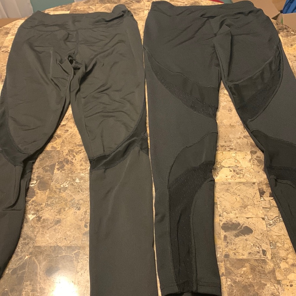 Two black workout leggings with mesh sheer panels